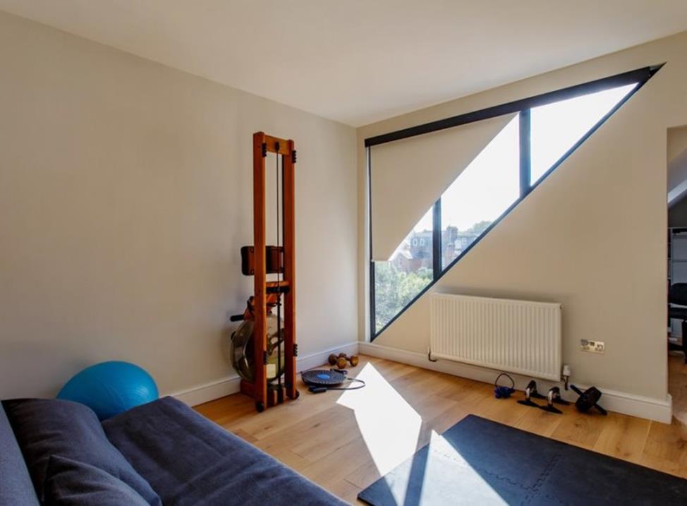 квартира с треугольным окном и рулонными шторами на нем