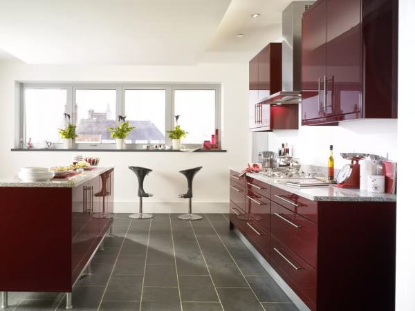 Резные фасады гарнитуров из натурального дерева матовых бордовых оттенков, дополненные позолоченной фурнитурой, выглядят роскошно и благородно