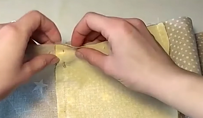 Булавка должна проходить прямо по линии шва обеих полос