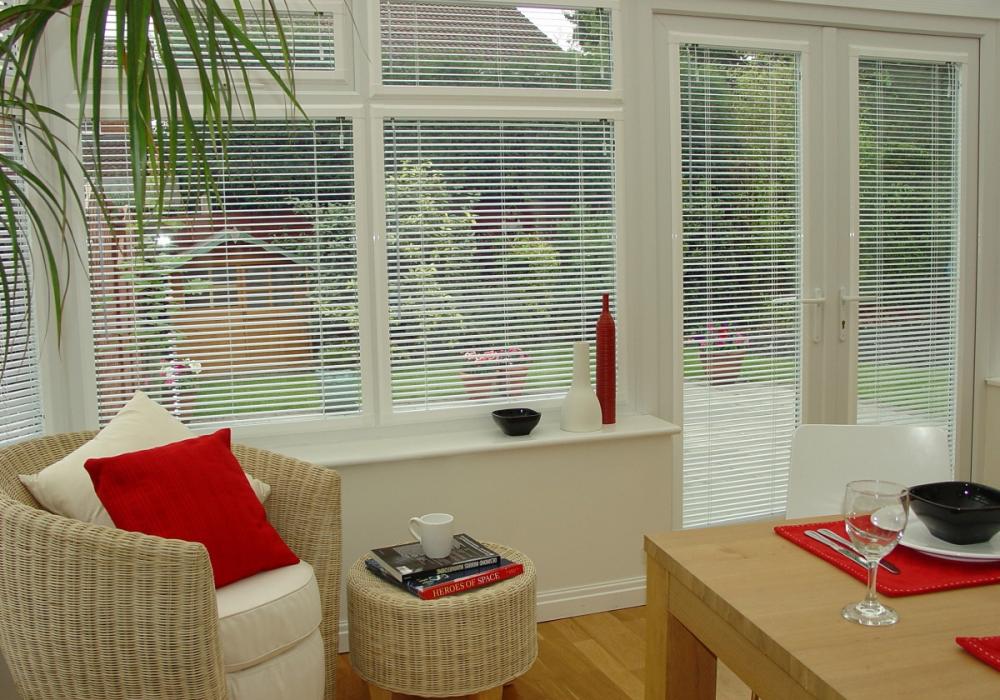 Горизонтальные белые жалюзи на балконной двери