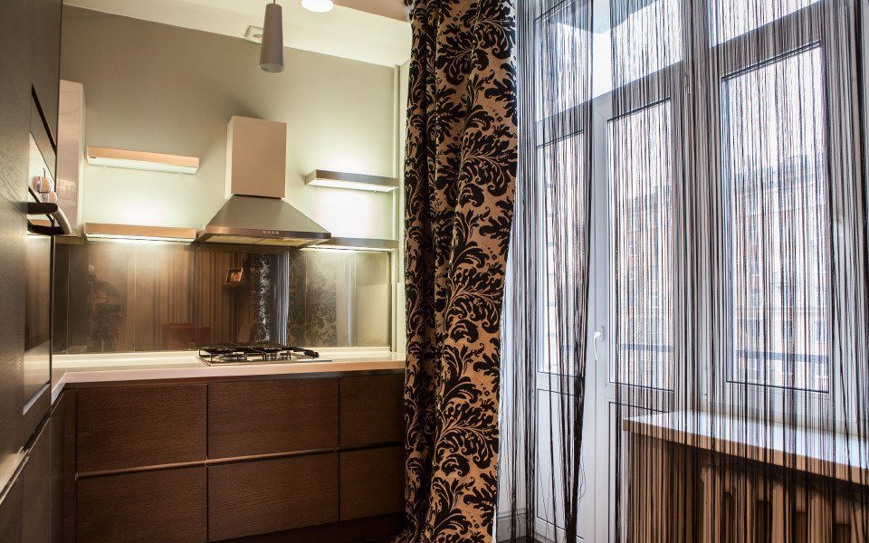 Темные нитяные шторы на кухне с балконом