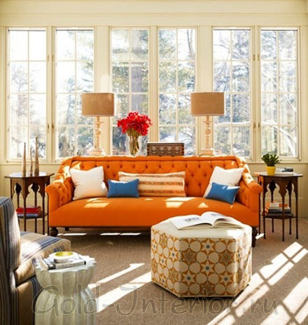 На фото - синие подушки и оранжевый диван